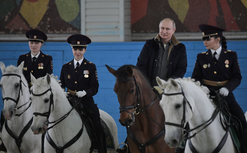 © Reuters. Presidente da Rússia, Vladimir Putin, cavalga ao lado de policiais mulheres em Moscou