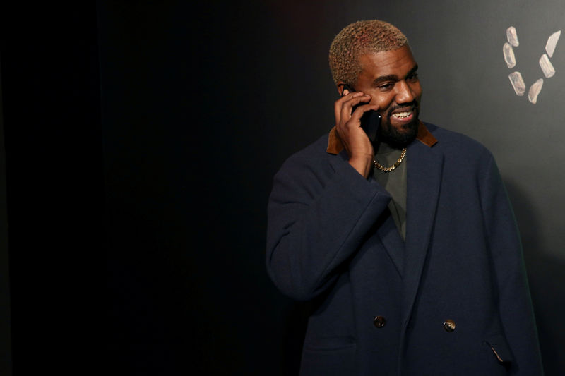© Reuters. FILE PHOTO: Rapper Kanye West talks on the phone before attending the Versace presentation in New York