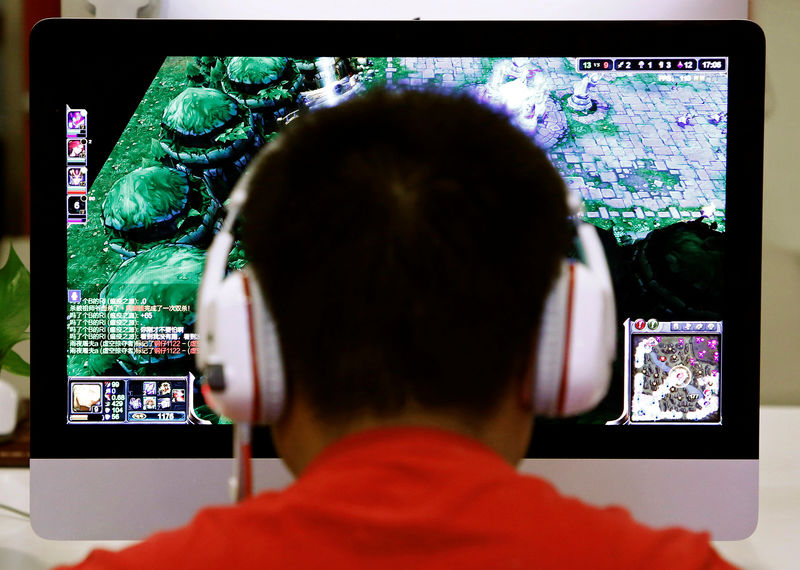 © Reuters. FILE PHOTO: A man plays a computer game at an internet cafe in Beijing