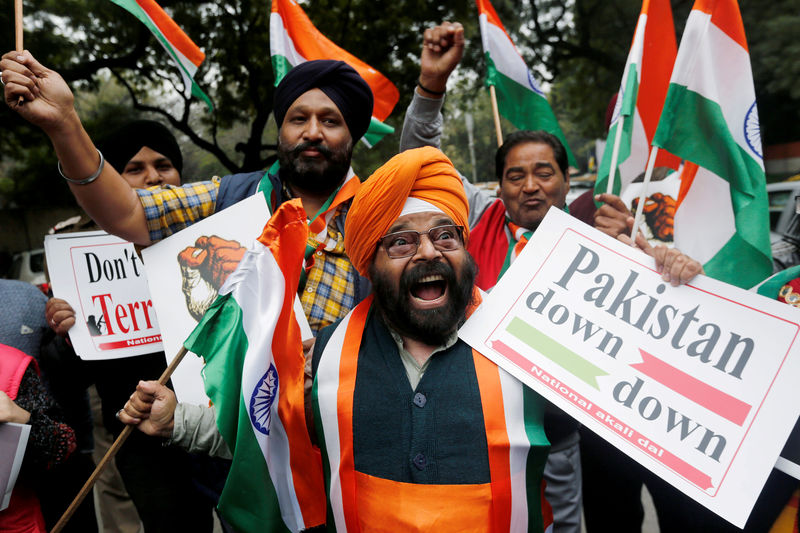 © Reuters. FILE PHOTO: People hold national flags and placards as they celebrate after Indian authorities said their jets conducted airstrikes on militant camps in Pakistani territory, in New Delhi