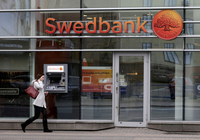 © Reuters. FILE PHOTO: A woman walks past Swedbank branch in Riga