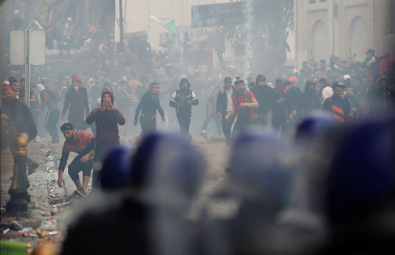 © Reuters. Anti-riot police officers clash with people protesting against President Abdelaziz Bouteflika, in Algiers