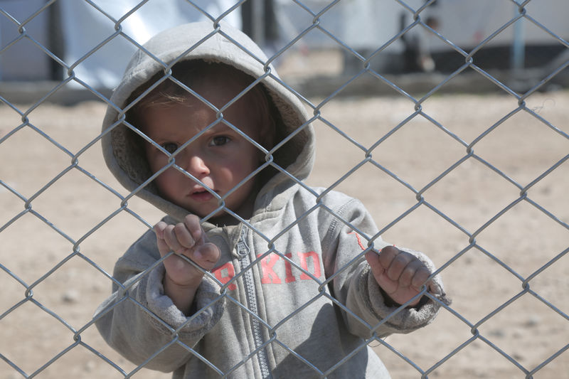 © Reuters. A child looks through a chain linked fence at al-Hol displacement camp in Hasaka governorate