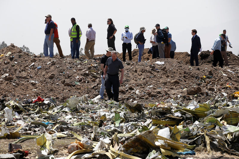 © Reuters. American civil aviation and Boeing investigators search through the debris at the scene of the Ethiopian Airlines Flight ET 302 plane crash, near the town of Bishoftu
