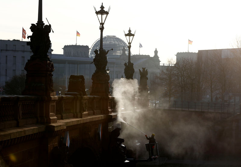 © Reuters. A worker cleans with hot steam the surface of Moltkebrueke Bridge near the Chancellery, in the early morning in Berlin