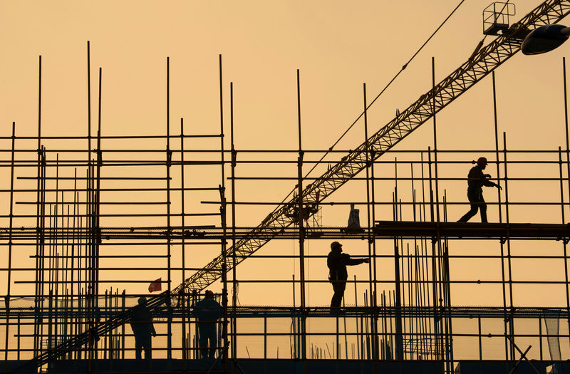 © Reuters. FILE PHOTO: Workers are seen on scaffolding at a construction site in Nantong