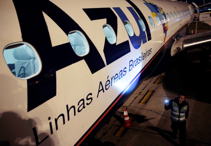© Reuters. Funcionário da Azul observa avião no Aeroporto Internacional de Guarulhos, SP