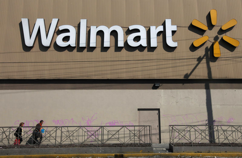 © Reuters. Two people walk outside a Wal-Mart store in Mexico City