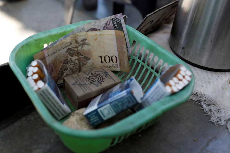 © Reuters. Venezuelan bolivar notes and cigarettes on sale are seen in a basket in downtown Caracas