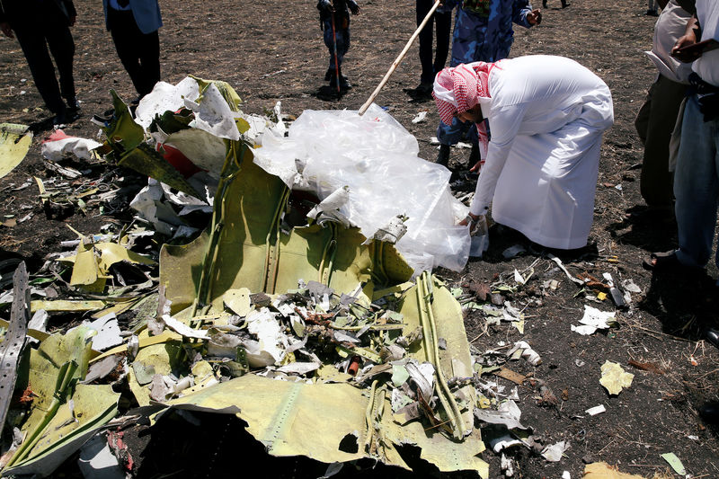 © Reuters. A Saudi man who's brother died in the Ethiopian Airlines Flight ET 302 plane crash, touches a debris after a commemoration ceremony at the scene of the crash, near the town of Bishoftu, southeast of Addis Ababa