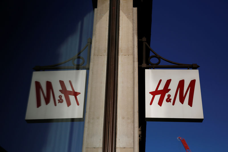 © Reuters. FILE PHOTO: A logo is reflected in the window as it hangs outside the H&M store on Oxford Street in London