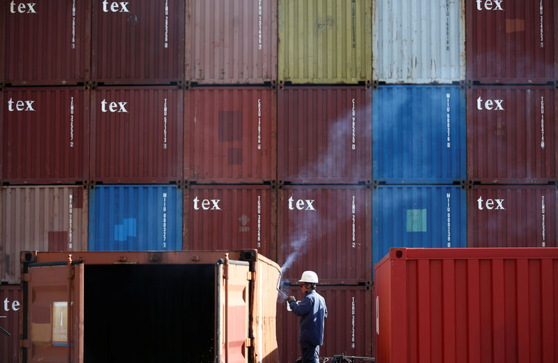 © Reuters. A man repairs a container at an industrial port in Tokyo