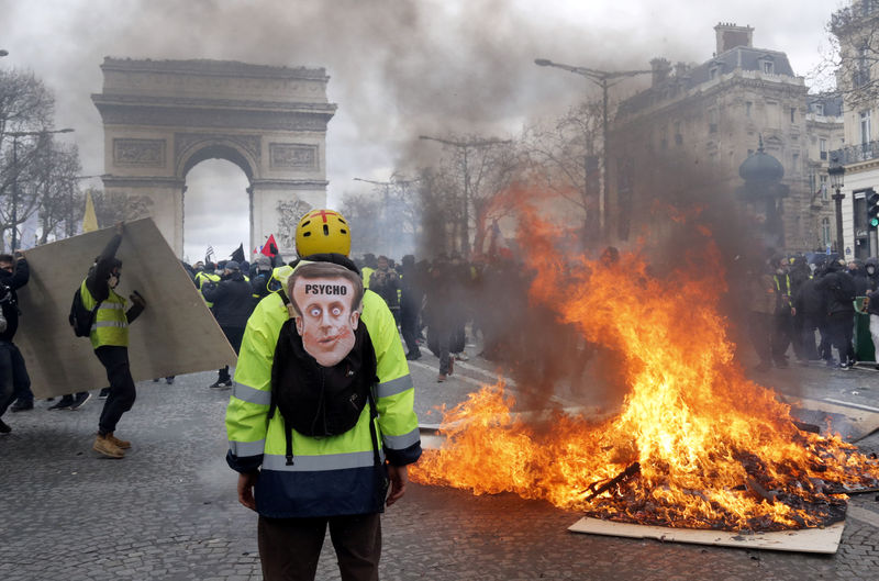 © Reuters. Un manifestante está de pie frente a una barricada en llamas durante las protestas de los "chalecos amarillos" en París