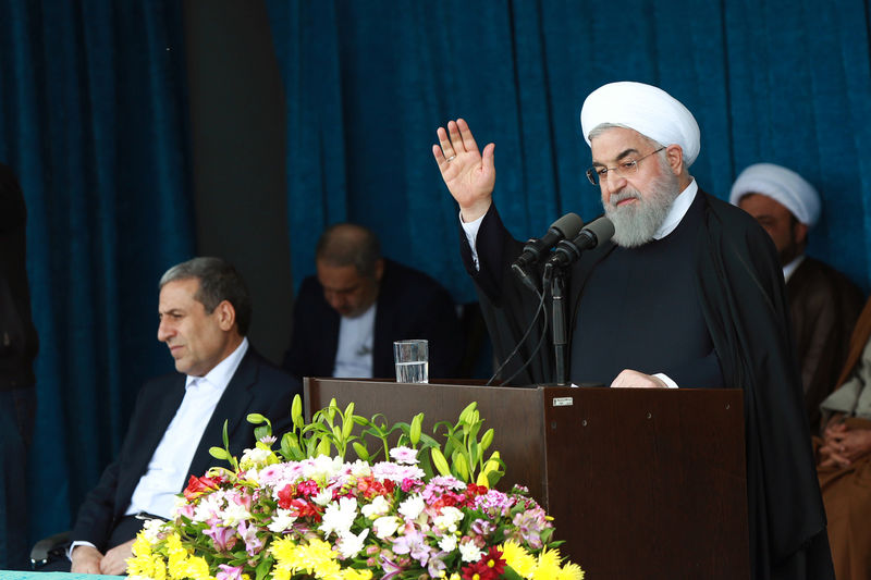 © Reuters. Iranian President Rouhani gestures to the crowd at a public speech in Bandar Kangan