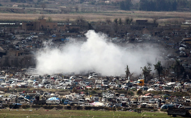 © Reuters. Smoke rises from the last besieged neighborhood in the village of Baghouz, Deir Al Zor province