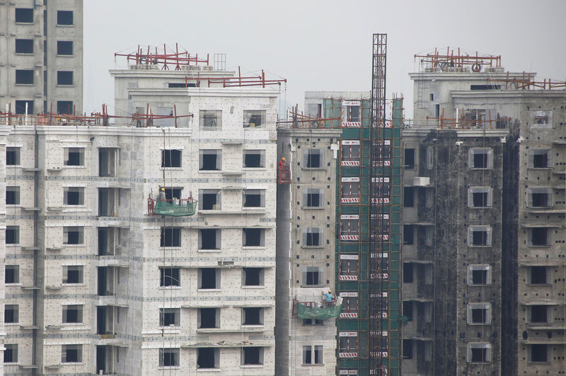 © Reuters. Men work at a construction site of residential apartment blocks in Beijing