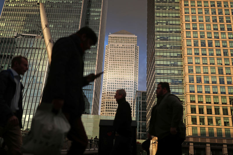 © Reuters. FILE PHOTO: People walk through the Canary Wharf financial district of London