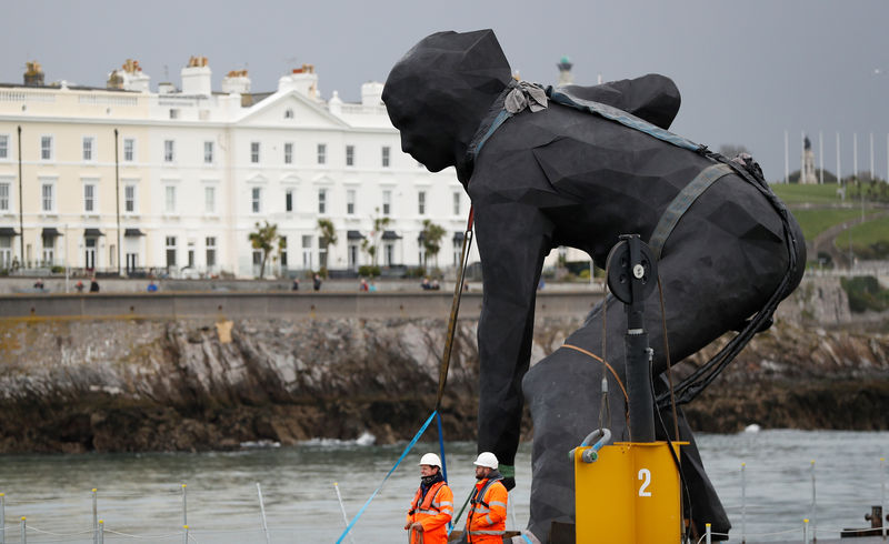 © Reuters. Britain's largest bronze sculpture, "Messenger" arrives by barge in Plymouth Sound before being taken by road to the Theatre Royal in Plymouth