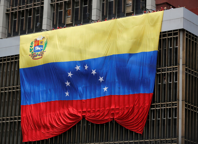© Reuters. FILE PHOTO: A Venezuelan flag hangs from a building near the national election board as acting President Maduro registered as a candidate for president in the April 14 election in Caracas