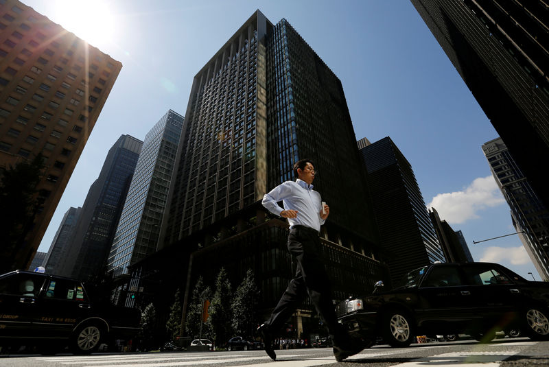 © Reuters. FILE PHOTO - A man runs on a crosswalk at a business district in central Tokyo