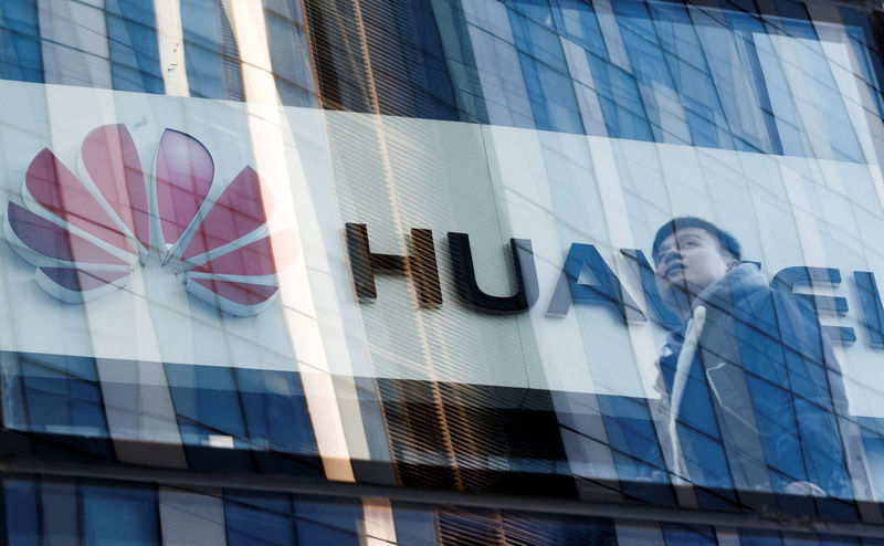 © Reuters. FILE PHOTO: A man walks past a Huawei shop in Beijing