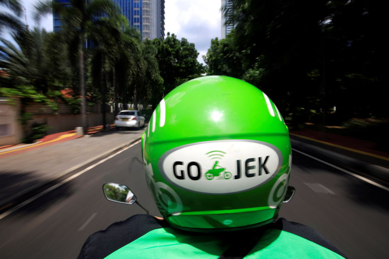 © Reuters. FILE PHOTO: A Go-Jek driver rides a motorcycle on a street in Jakarta, Indonesia