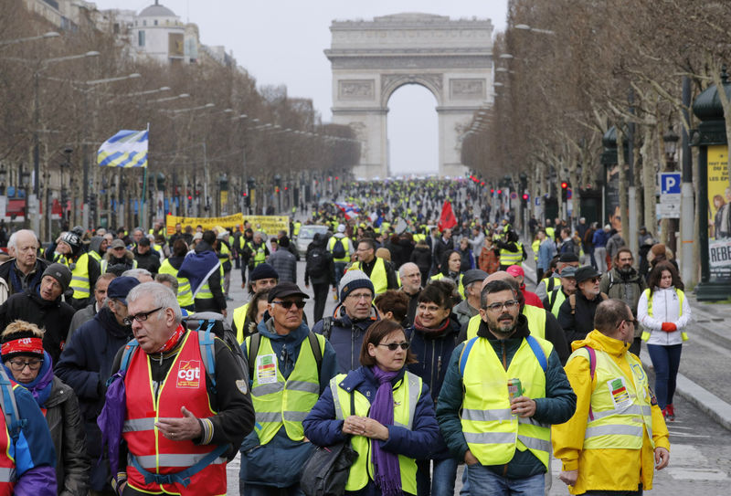 © Reuters. FILE PHOTO: Protesters wearing yellow vests walk down the Champs Elysees during a demonstration by the "yellow vests" movement in Paris