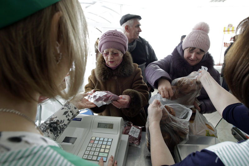 © Reuters. People buy goods at a shop of the "Russia" collective farm in the settlement of Grigoropolisskaya