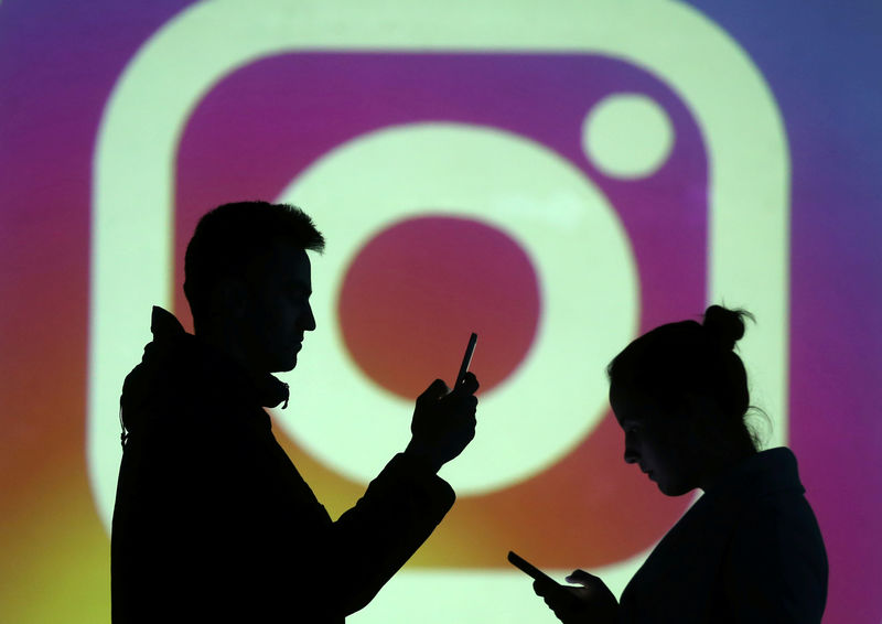 © Reuters. En la imagen, siluetas de personas ante un logo de Instagram