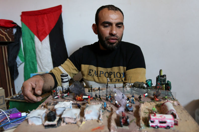 © Reuters. En la imagen, el artista palestino Majdi Abu Taqeya trabaja con figuras en miniatura con restos de munición israelí