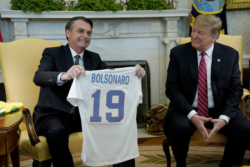 © Reuters. Presidente Jair Bolsonaro recebe camisa da seleção de futebol dos EUA do presidente norte-americano, Donald Trump, na Casa Branca