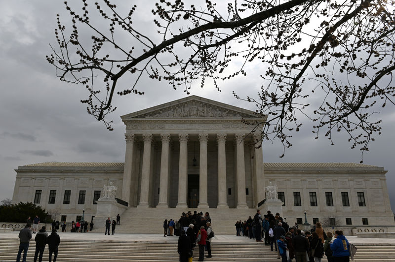 © Reuters. FILE PHOTO: People wait in line outside the U.S. Supreme Court to hear the orders being issued, in Washington