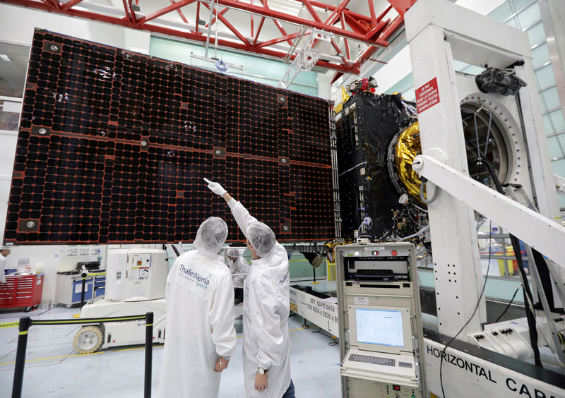 © Reuters. FILE PHOTO: A technician looks at a solar panel on an Inmarsat satellite in a clean room at the Thales Alenia Space plant in Cannes