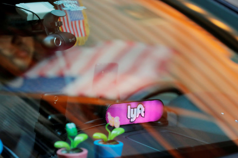 © Reuters. FILE PHOTO: A car with a Lyft logo in its window drives down a street as the company prepares for its upcoming IPO in New York