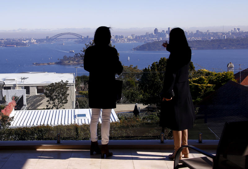 © Reuters. FILE PHOTO: The Sydney Opera House and Harbour Bridge can be seen behind a real estate agent and buyer in the Sydney suburb of Vaucluse, Australia