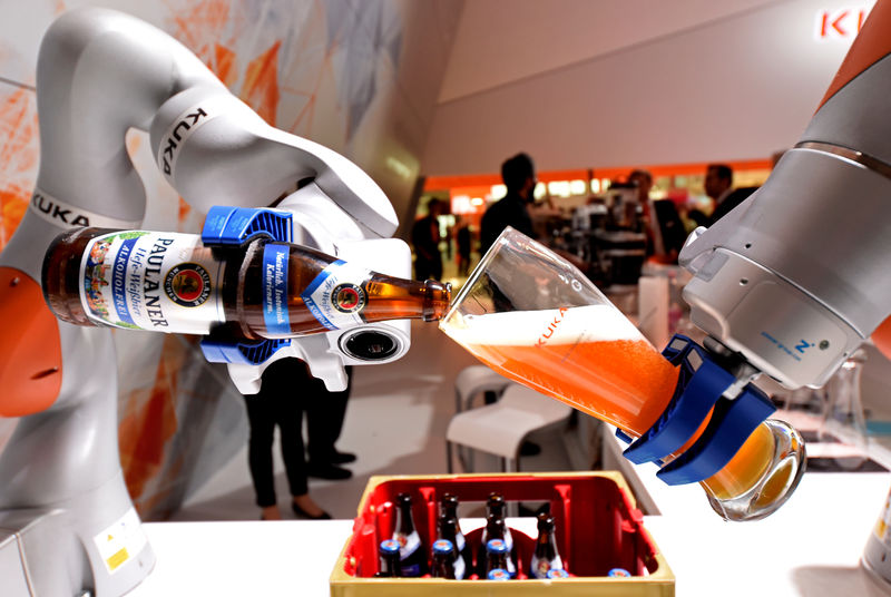 © Reuters. FILE PHOTO: A robotic arm fills a glass with Bavarian Weiss beer at the booth of German company Kuka at the world's biggest industrial fair, "Hannover Fair\\