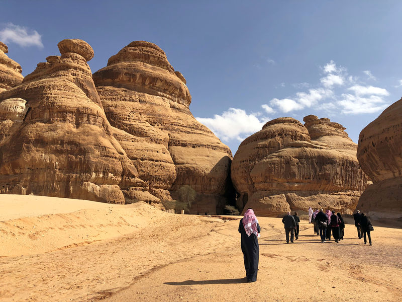 © Reuters. Visitors walk outside the tombs at the Madain Saleh antiquities site, al-Ula