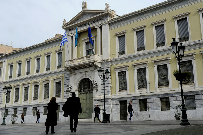 © Reuters. People make their way past the National Bank of Greece headquarters in central Athens