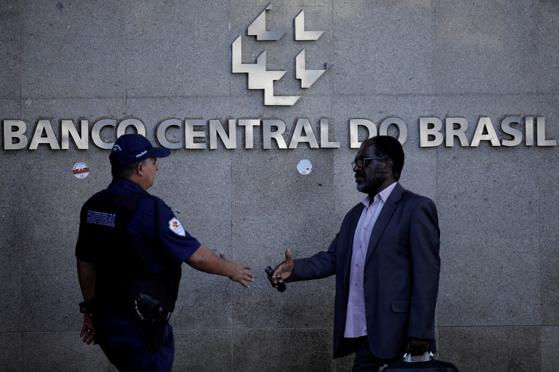 © Reuters. FILE PHOTO: People walk outside the central bank headquarters building in Brasilia