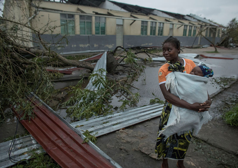 © Reuters. Mulher carrega criança em Beira, região devastada pelo ciclone Udai, em Moçambique