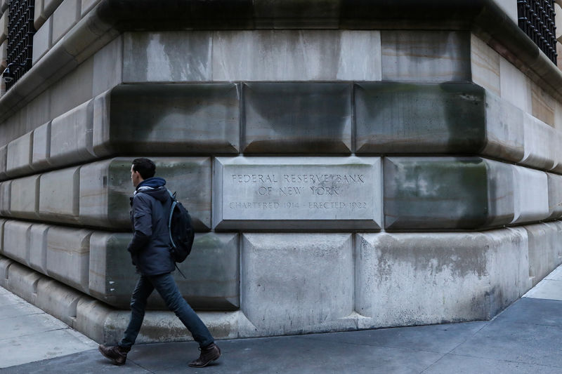 © Reuters. A man passes by the corner stone on the Federal Reserve Bank of New York in the financial district in New York