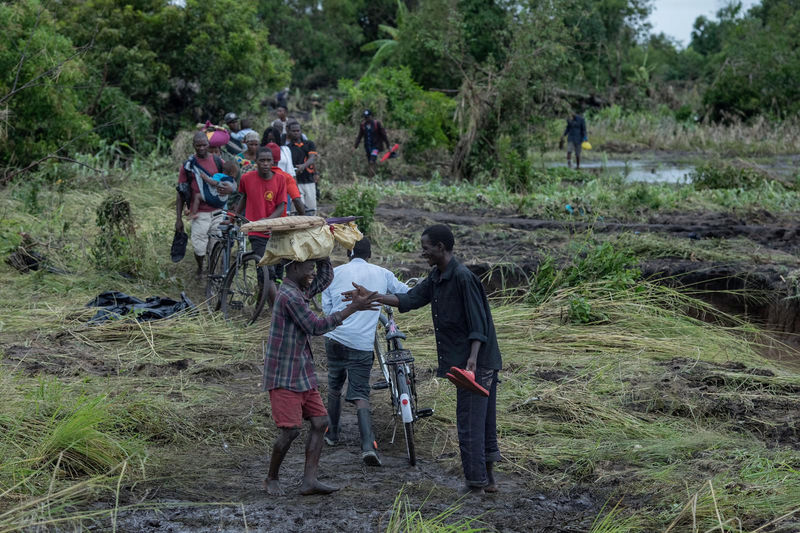 © Reuters. People affected by Cyclone Idai walk in Beira