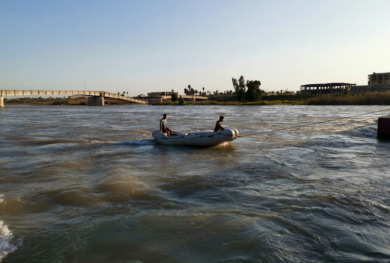 © Reuters. Equipes de resgate buscam por sobreviventes no local onde uma balsa naufragou no rio Tigre, perto de Mosul, no Iraque