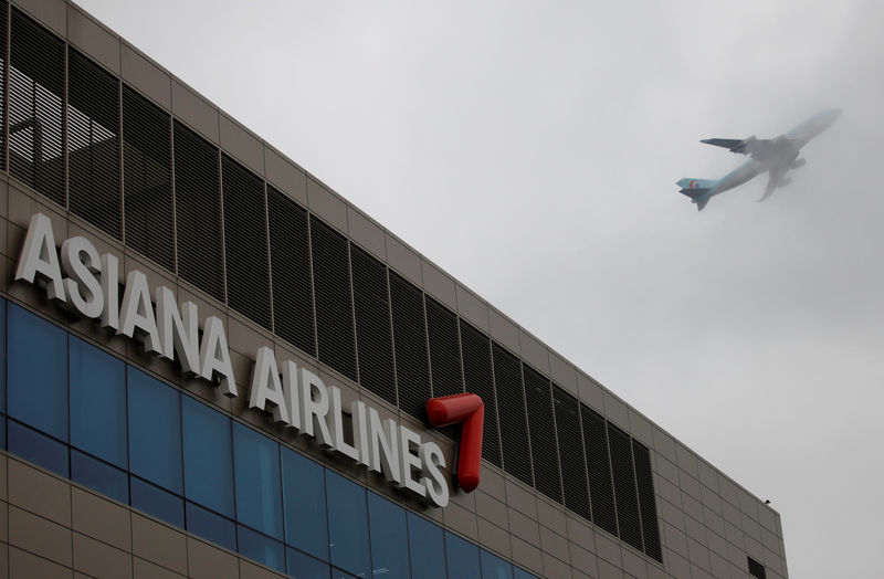 © Reuters. FILE PHOTO: Aircraft flies over the head office of Asiana Airlines in Seoul