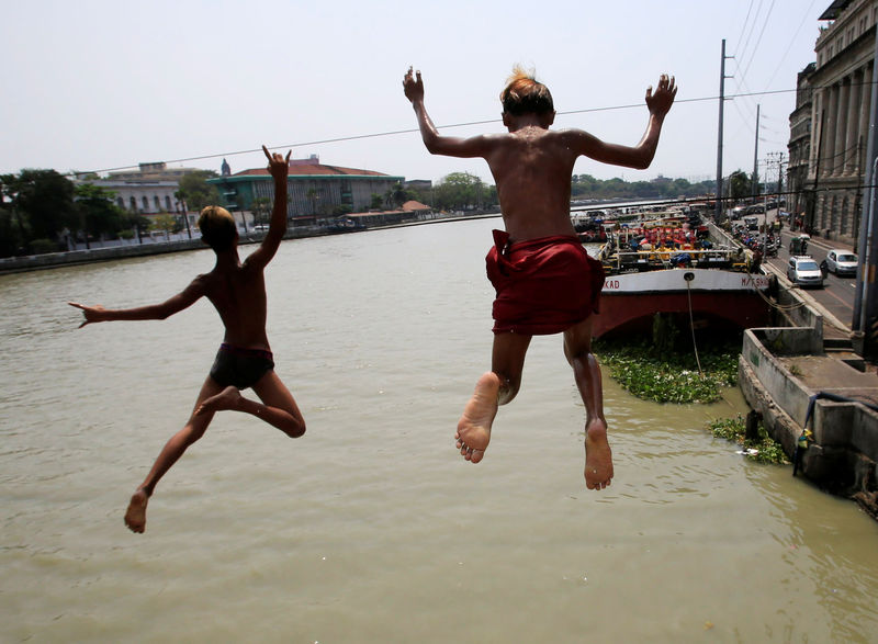 © Reuters. Meninos mergulham em águas poluídas em Manila, nas Filipinas