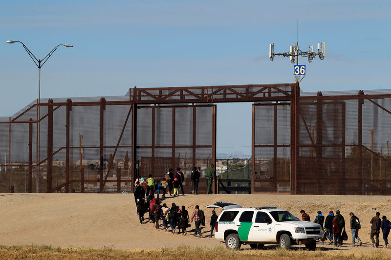 © Reuters. FILE PHOTO: Migrants from Central America are seen escorted by U.S. Customs and Border Protection officials after crossing the border from Mexico to surrender to the officials in El Paso, Texas, U.S., in this pictured taken from Ciudad Juarez