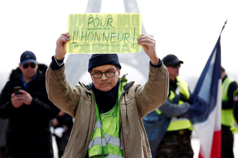 © Reuters. A protester holds a placard in front of Eiffel Tower during Act XIX of the "yellow vests" movement in Paris