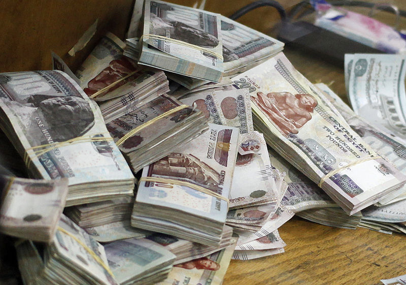 © Reuters. Stacks of money are pictured as an employee counts them at a bank in Cairo