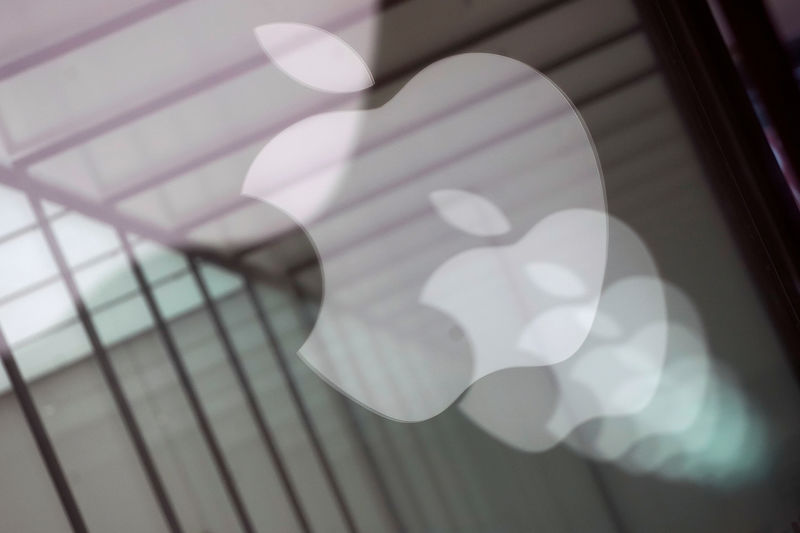 © Reuters. FILE PHOTO: Apple company logos are reflected on the glass window outside an Apple store in Shanghai