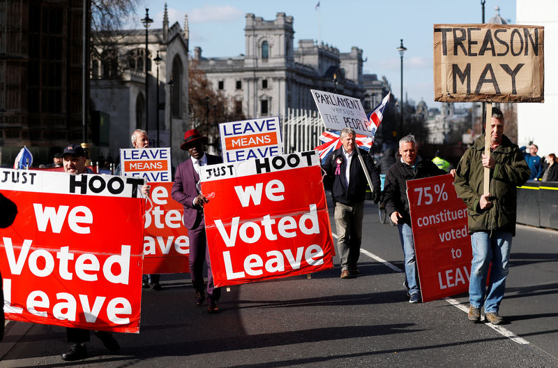 © Reuters. Pro-Brexit protesters walk outside the Houses of Parliament in London